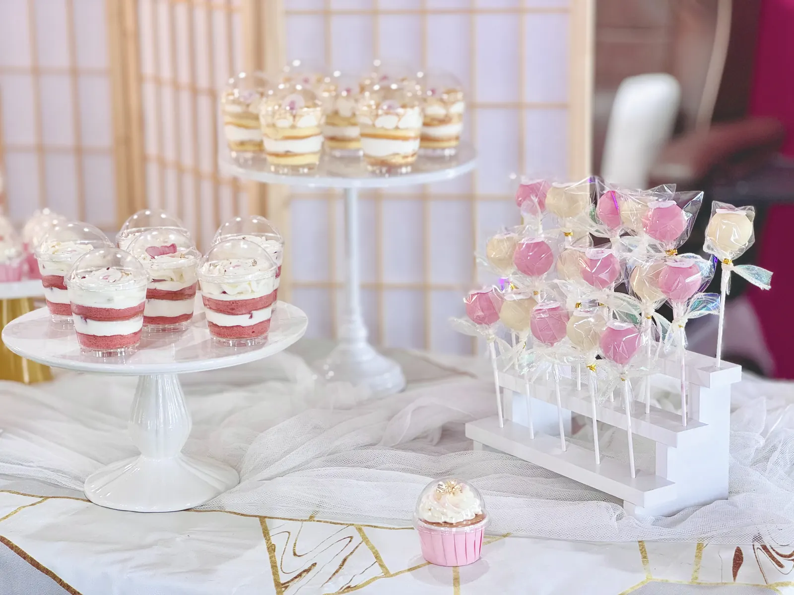 Dessert cups and cake pops on white stands