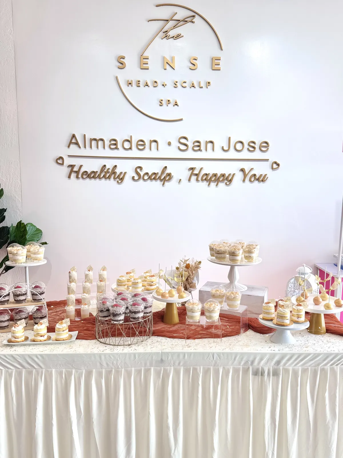 Dessert table set in front of a business logo wall