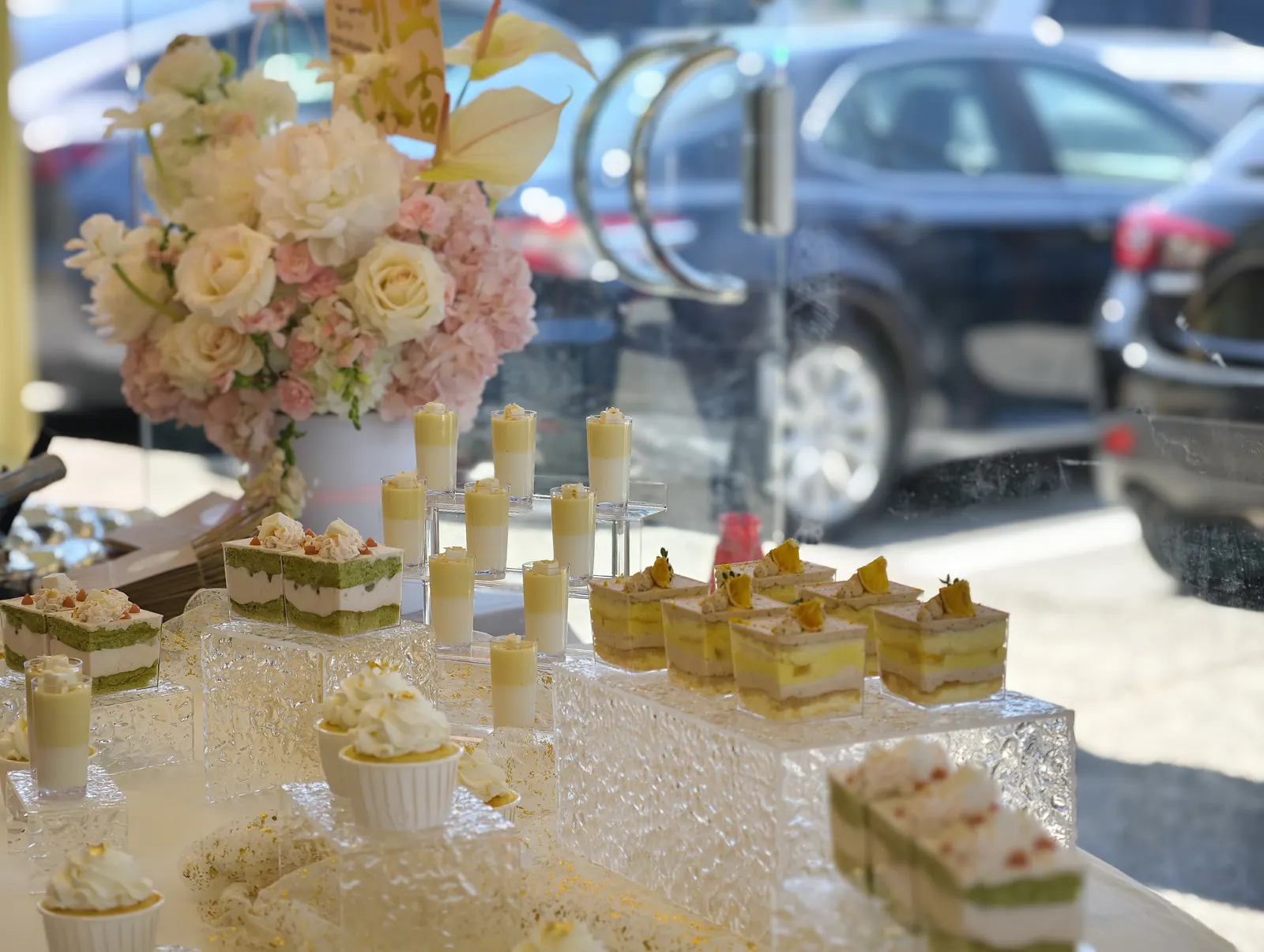 Matcha cakes and dessert cups with a pink floral arrangement