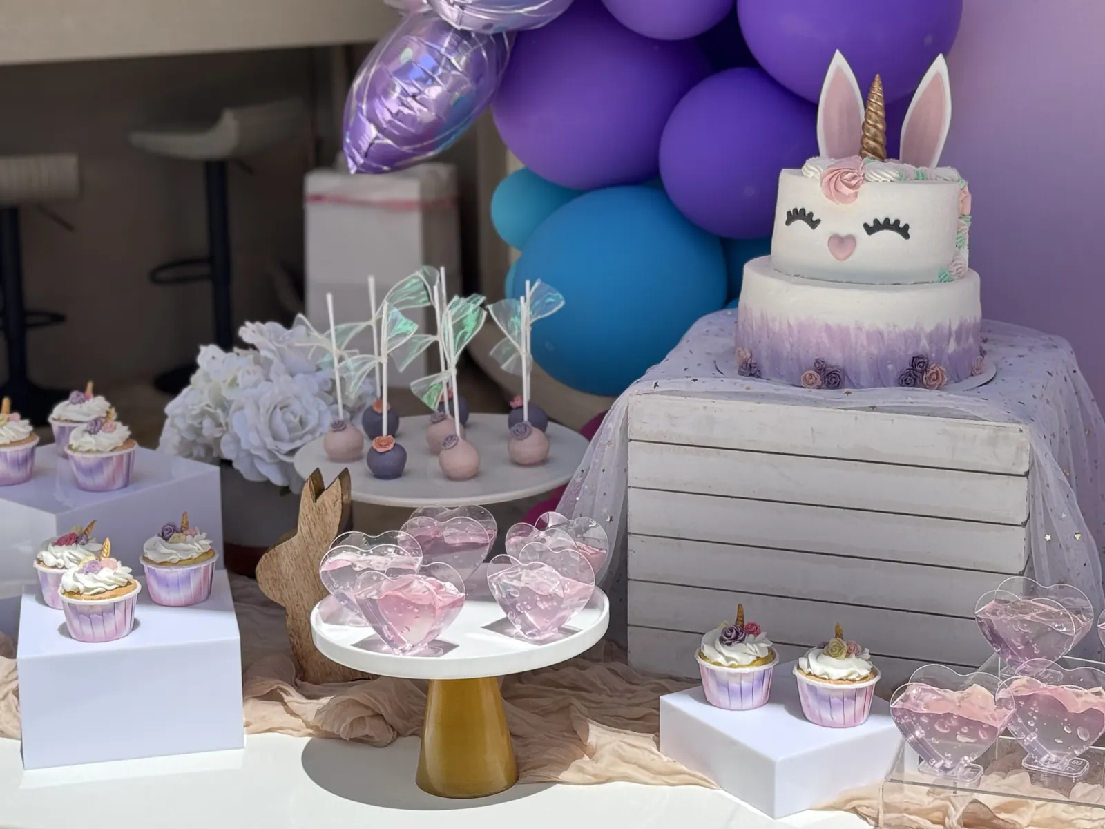 Bunny cake with purple balloons and pastel desserts