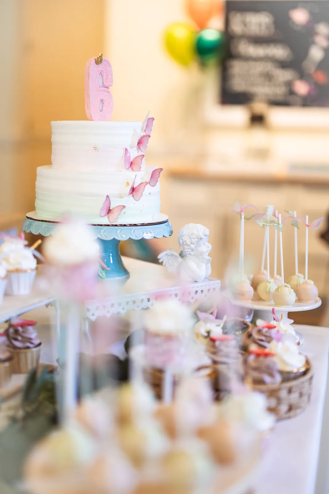 Tiered celebration cake with cake pops in soft focus