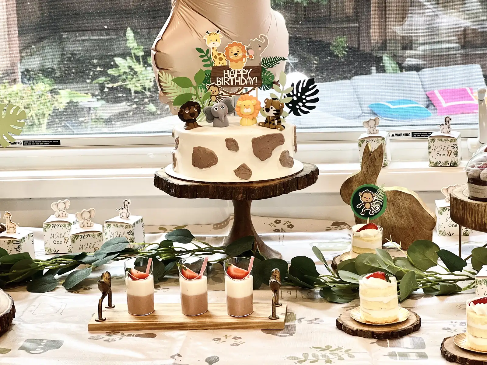 Animal-print birthday cake with mousse cups and greenery